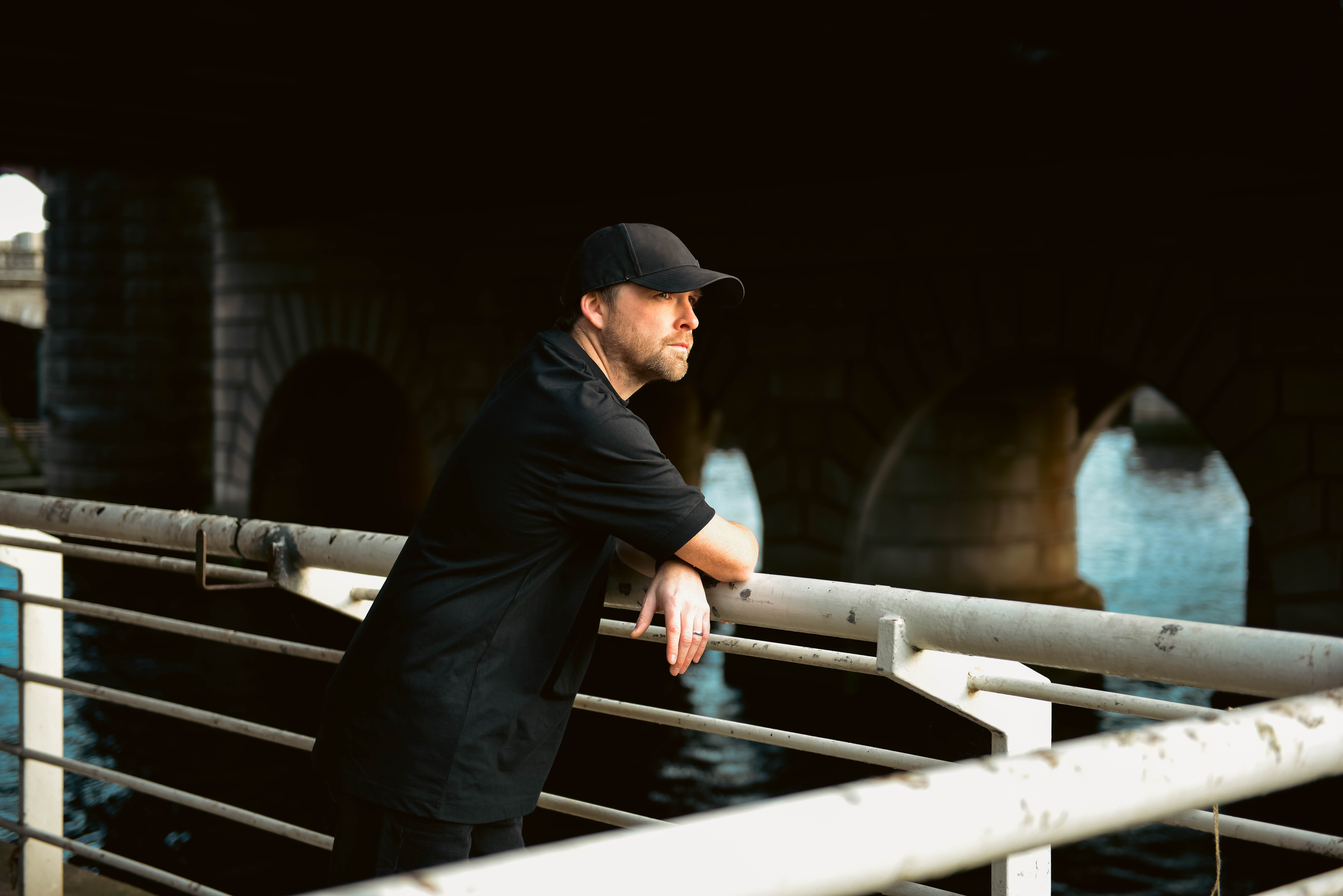 Gary Beck lehnt an einem Geländer am Fluss
