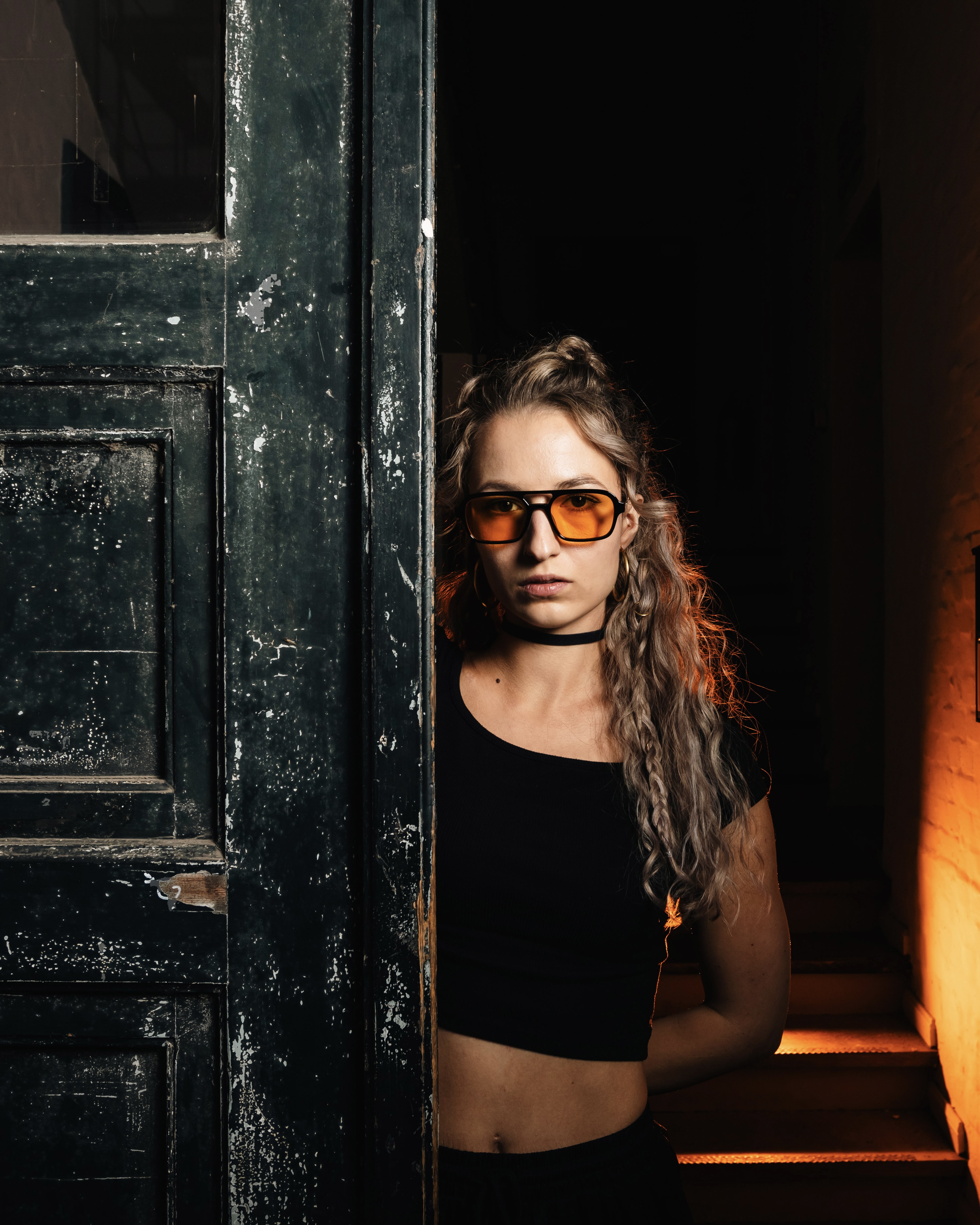 Tommahawk mit Sonnenbrille lehnt an einer Eingangstür
